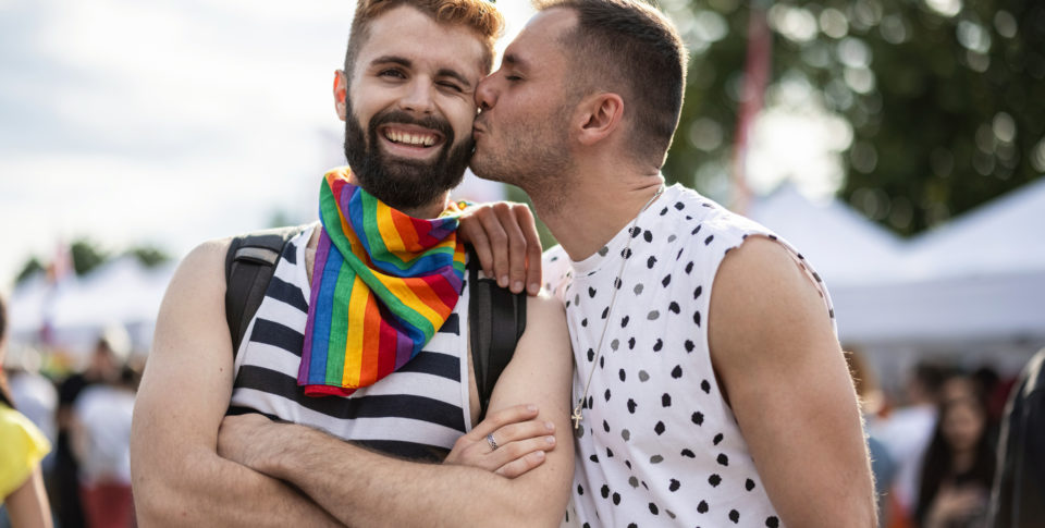 Attractive couple kissing on pride parade