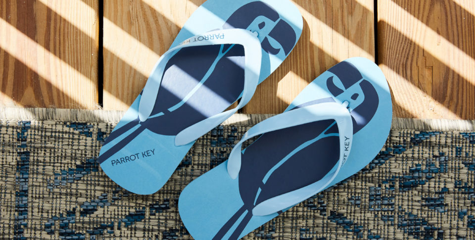 Parrot Key branded Flip Flops covered in light strikes from a nearby window